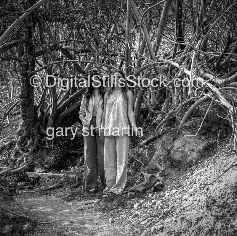 Two Girls Surrounded by Branches in Woods, black and white analog groups