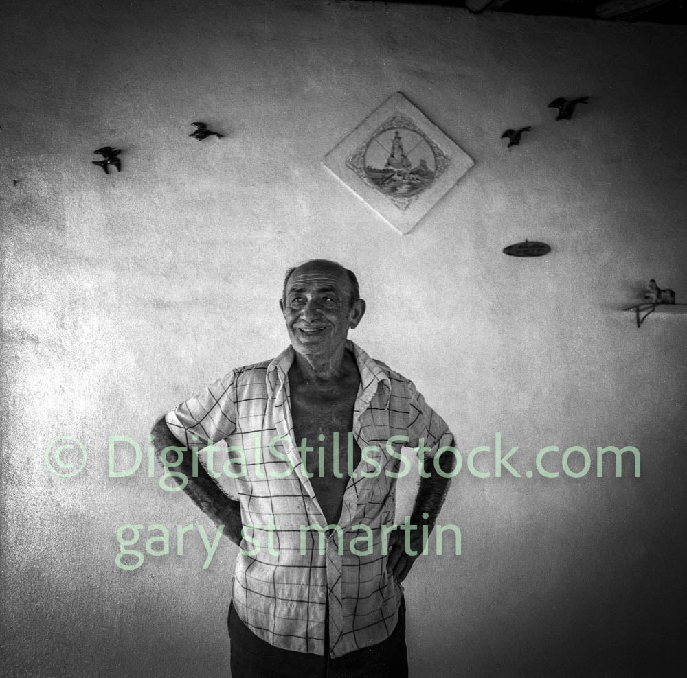 Black and white portrait of a man standing in front of a wall with decorative elements.