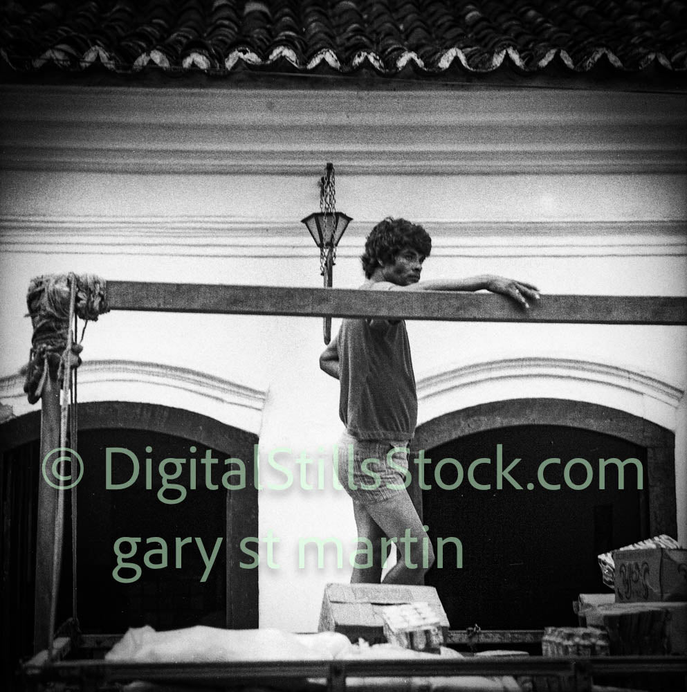 Black and white photo of a person standing on a balcony with architectural details