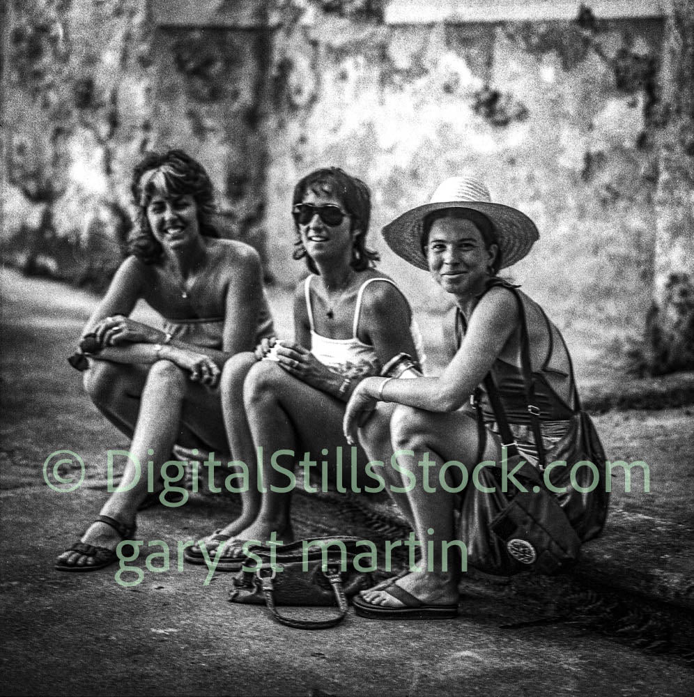 Three women sitting together outdoors with a vintage feel