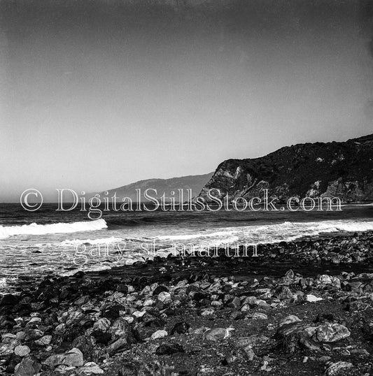 Distant Mounds Across Rocky Beach in California
