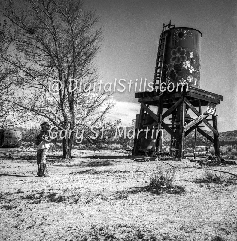 She walks alone by an outdoor water tank, Black & White, Oddities