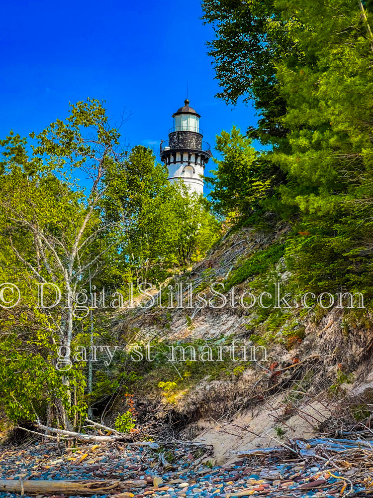 Sable Lighthouse peaking through the trees from the shore, digital Grand mArais