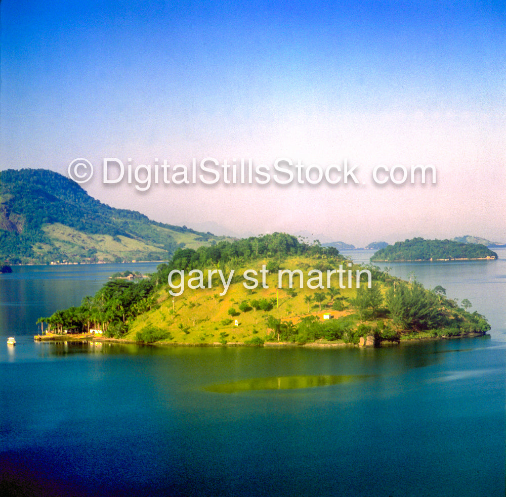 Island in a body of water with mountains in the background