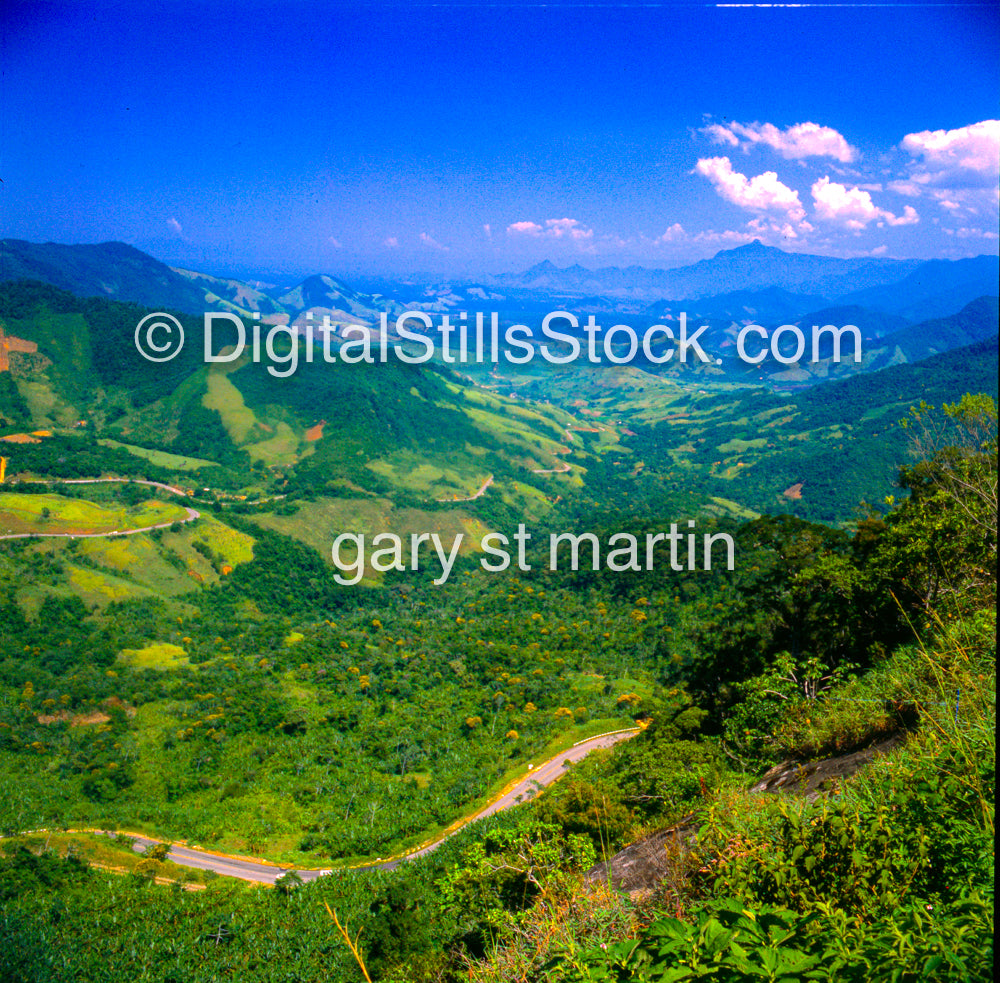 Scenic view of green valleys and mountains with a clear blue sky.
