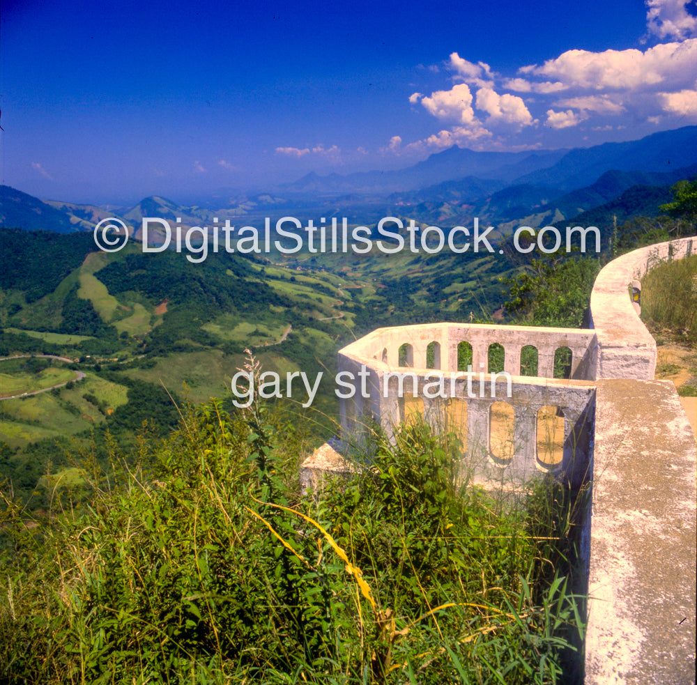 Ancient stone building amidst green hills and blue sky