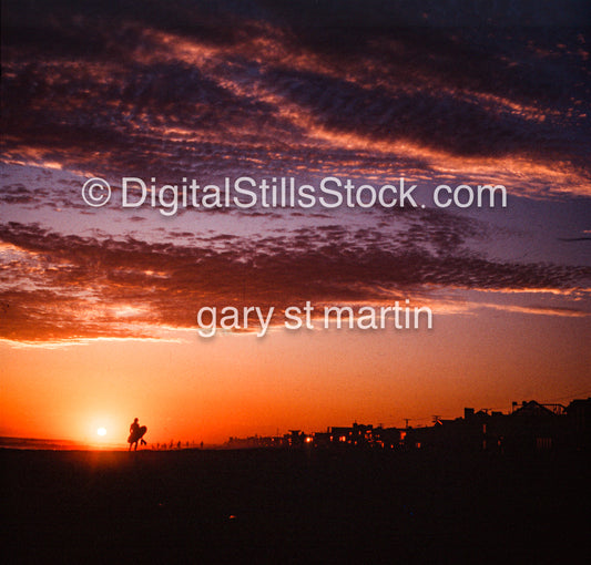 Silhouette of a surfer in front of a flaming sky, analog sunsets