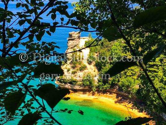 Miner's Castle behind silhouettes of tree branches , digital Munising