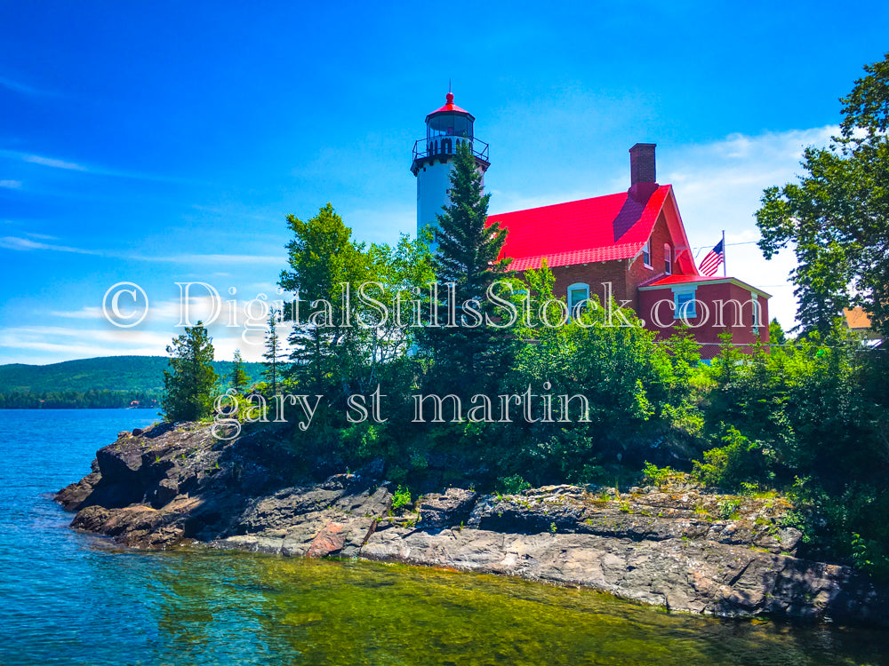 Bright red lighthouse along the blue green water, digital copper harbor