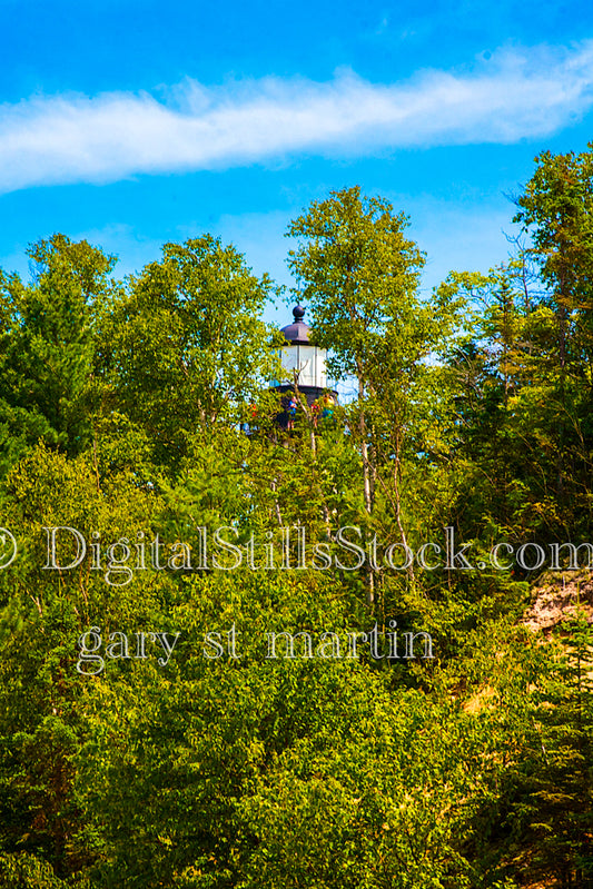 Top of the lighthouse peaking out through the trees, digital Grand Marais