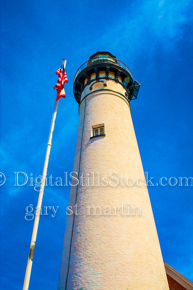 Portrait looking up a at the Sable Lighthouse next to the flag, digital Grand Marais