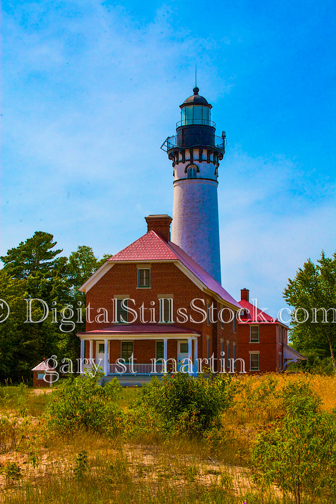 Portrait of the Sable lighthouse alongside a red brick building, digital Grand Marais