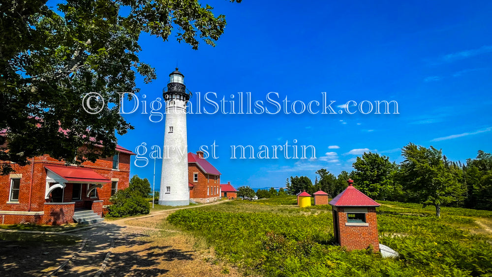 Wide View of Sable Lighthouse amidst buildings, digital Grand Marais