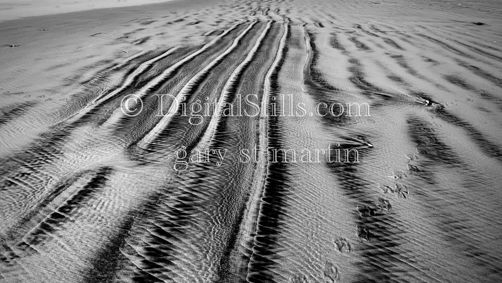 Black and white treads in the sand, digital sunset